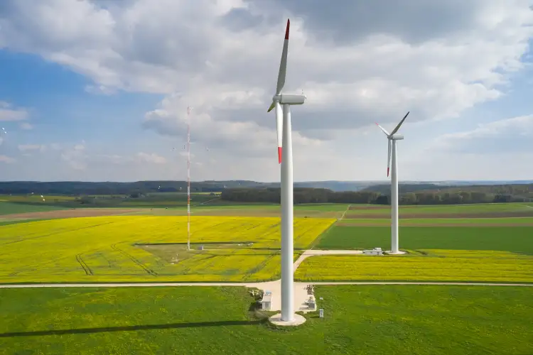 Seitenansicht von zwei Windenergieanlagen und einem Messmast